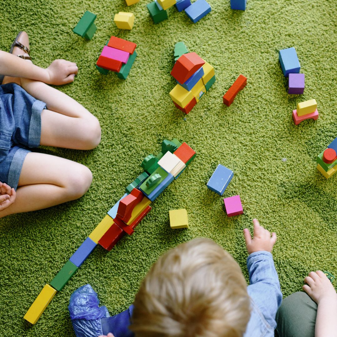 Immagine fotografica di bambini che giocano al tappeto per rappresentare una possibile seduta di terapia della neuro e psicomotricità di gruppo. La sezione indica come prenotare un appuntamento con le terapiste.